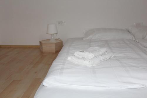 a white bed with towels on it in a room at Lemonwood House in Postojna