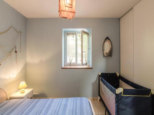 a bedroom with a bed and a window at Slate-Roofed Hideaway in Cressensac