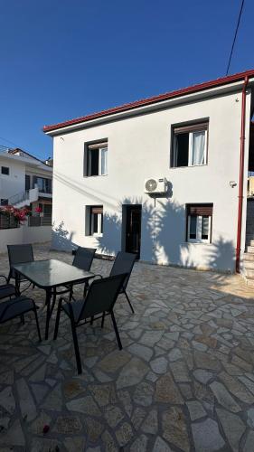 a patio with a table and chairs in front of a building at Steven Eleonas apartments in Eleonas
