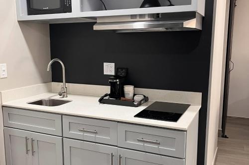 une petite cuisine avec un évier et un micro-ondes dans l'établissement Howard Johnson by Wyndham Flagstaff University West, à Flagstaff