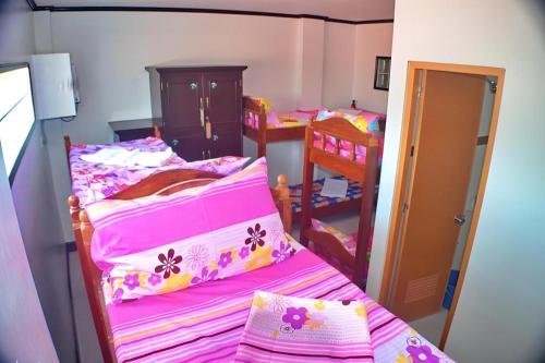 a bedroom with two bunk beds with pink sheets at Mayon Backpackers Hostel in Legazpi