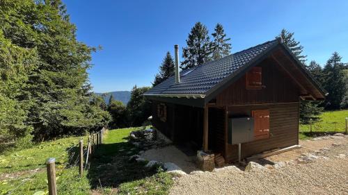 a small cabin in a field with trees at Beautiful Bernese Jura chalet 