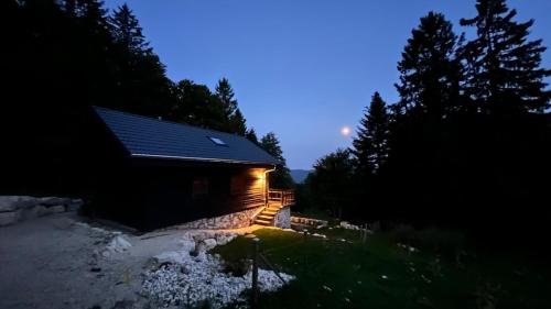 a cabin with a lighted porch at night at Beautiful Bernese Jura chalet 