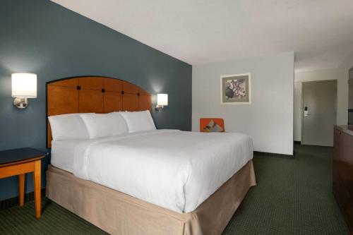 a hotel room with a large bed and a desk at Baymont by Wyndham Salem Roanoke Area in Salem