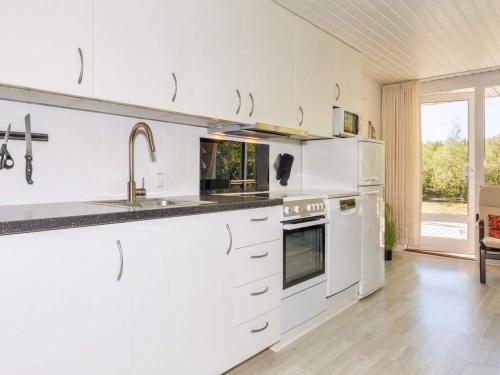 a white kitchen with a sink and a stove at 4 star holiday home in Fur in Fur