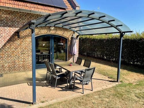 a wooden table and chairs under a pergola at Coachman's House near Roermond with Garden in Sint Odiliënberg