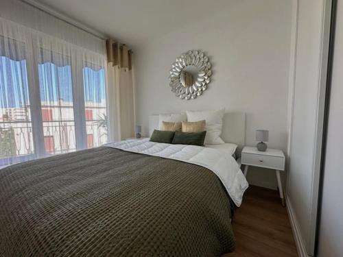 a bedroom with a large bed with a mirror on the wall at Bright 1Bedroom Apartment, Steps to Juan les Pins Beach in Antibes