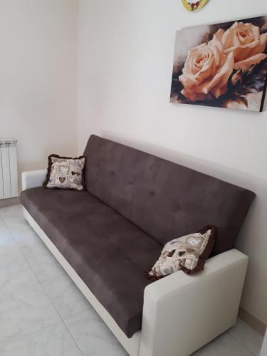 a couch in a living room with a painting on the wall at Xiridia house paradise in Floridia