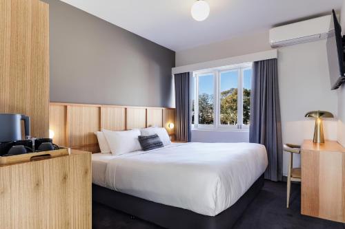 a bedroom with a large bed and a window at Kingsgrove Hotel in Sydney