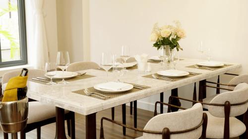 a white table with chairs and a vase of flowers at Swiss-Belvillas Solavita Binh Tien in Binh Tien