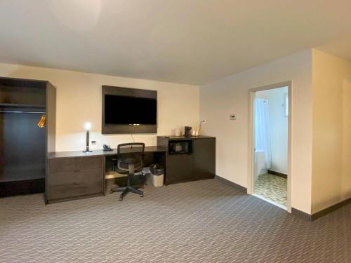a hotel room with a desk and a television at Rodeway Inn in Gaspé