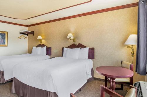 a hotel room with two beds and a table at Rodeway Inn in Gaspé
