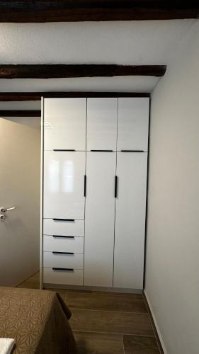 a white cabinet in a room with a bed at Steven Eleonas apartments in Eleonas