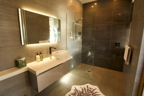 a bathroom with a sink and a mirror at Te Rongo Executive Villa in Parua Bay