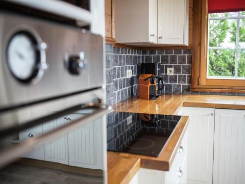 a kitchen with white cabinets and a clock on the counter at Luxury Wellness Villa, Septon in Durbuy