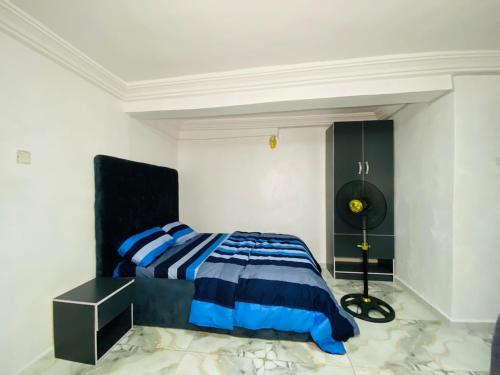 a bedroom with a bed and a black and blue comforter at Cosy lovely studio apartment in Lagos in Ijaiye