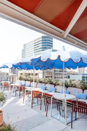 a row of tables and chairs with blue umbrellas at Hyatt Centric Congress Avenue Austin in Austin