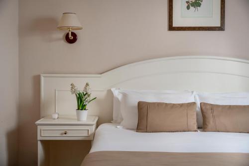 a bedroom with a white bed and a table with a lamp at Hotel Ercolini & Savi in Montecatini Terme