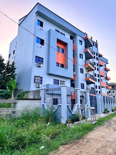 a blue building with colorful windows on the side of it at Résidence Prestige KGV in Douala