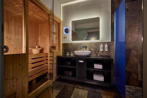 a bathroom with a sink and a mirror at Haven Hotel Rotterdam, Curio Collection by Hilton in Rotterdam