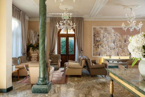 a living room filled with furniture and a chandelier at Hotel Ercolini & Savi in Montecatini Terme