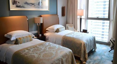 a hotel room with two beds and a window at Xian Jue Vu Hotel in Xi'an