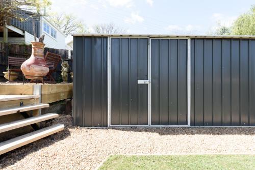 a black fence in a yard with a vase at Cosy Getaway with outdoor spaces in Launceston