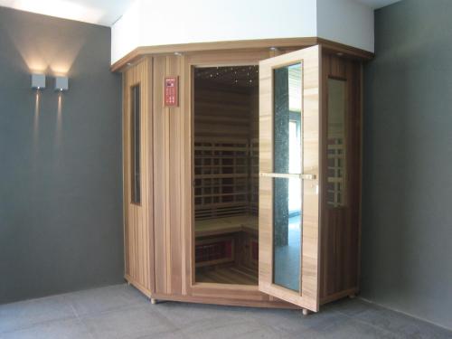 a wooden cabinet with a glass door in a room at Beernem Farmhouse with Pool in Beernem