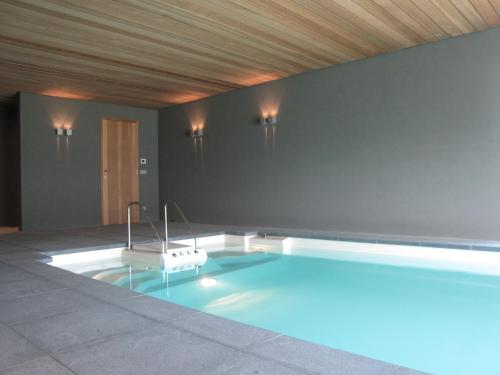 a swimming pool in the middle of a room at Beernem Farmhouse with Pool in Beernem