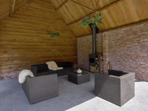 a living room with wicker furniture and a fireplace at Farmhouse in Zuidzande near Cadzand Beach in Zuidzande