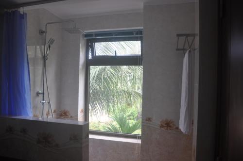 a bathroom with a shower and a window with a shower curtain at Tra Que Riverside Homestay in Hoi An