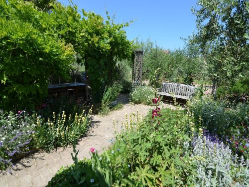 a garden with a bench and some flowers at Sunny Coastal Apartment in Gatteo a Mare