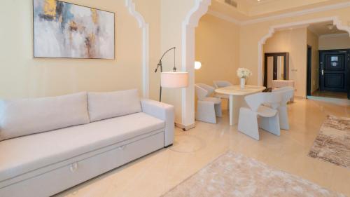 a living room with a white couch and a table at The Grand Hamra Stay by Hala Holiday Homes in Ras al Khaimah