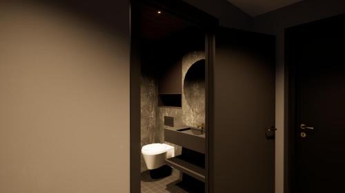 a bathroom with a white toilet in a dark room at Jauri Resort in Kemijärvi