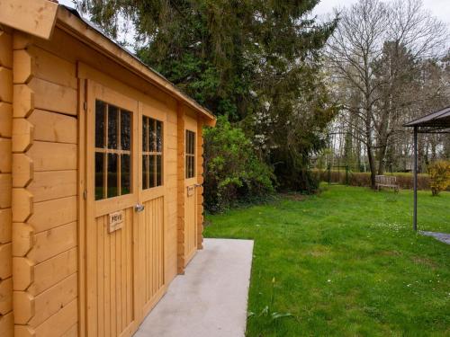 a wooden shed with a door next to a yard at Peaceful Garden Hideaway in Cerfontaine