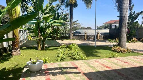 a garden with palm trees and a table at Kilimani Apartment in Arusha