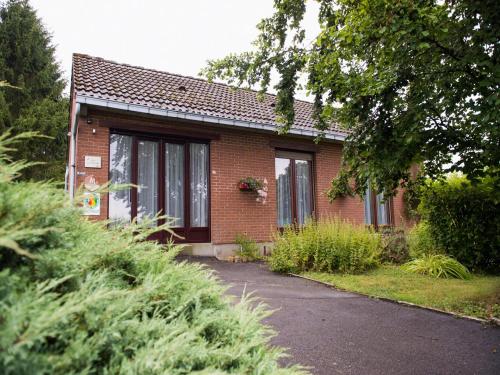 a small red brick house with a driveway at Peaceful Garden Hideaway in Cerfontaine