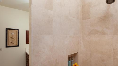 a shower with a large stone wall in a bathroom at COCONUT TELEGRAPH Rejuvenating 3BR Villages Home Near Recreation Center in Waikoloa