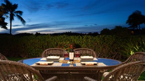 a table with three chairs and a table with a table at COCONUT TELEGRAPH Rejuvenating 3BR Villages Home Near Recreation Center in Waikoloa