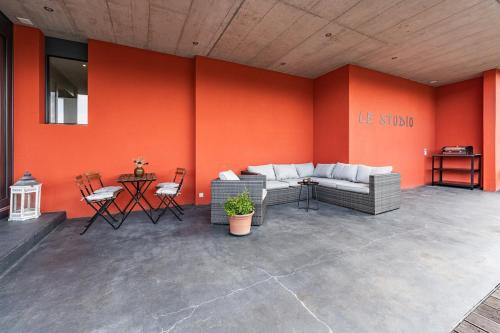 a patio with a couch and a table with chairs at Light-filled studio with panoramic views in Oberhofen am Thunersee
