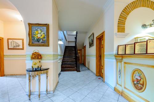 a hallway with stairs and a table with a vase on it at Hotel Casa De La Rosa in Timişoara