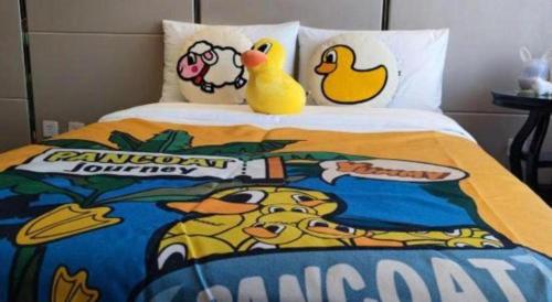 two rubber ducks are sitting on a bed at Hohhot Inner Mongolia Hotel in Hohhot