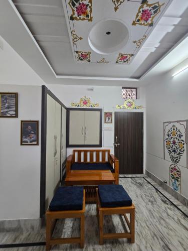 a room with two beds and a ceiling with paintings at little Princess Guest House in Bikaner