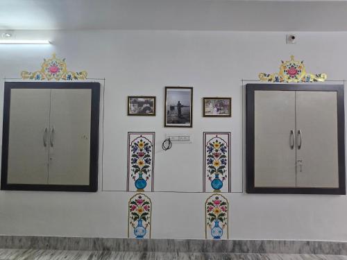 a white wall with mirrors and mosaics on it at little Princess Guest House in Bikaner