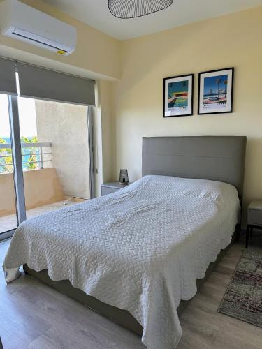 a bedroom with a bed with a white comforter at Seaview Apartment in Limassol in Limassol