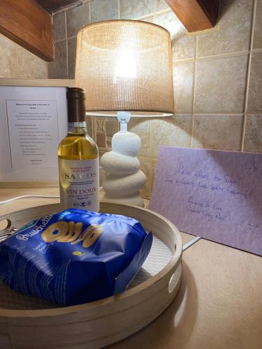 a bottle of wine on a table next to a lamp at Cosy Nest Apartment in the Heart of Samos in Samos