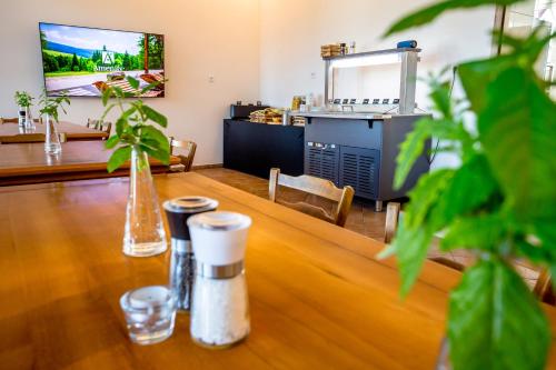 a table in a restaurant with a kitchen in the background at Amenity Apartmány Perná in Perná