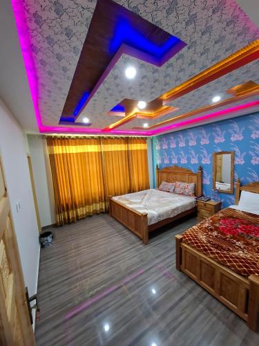 a bedroom with two beds and a purple ceiling at Eagle Resort Hotel and Restaurant in Nārān