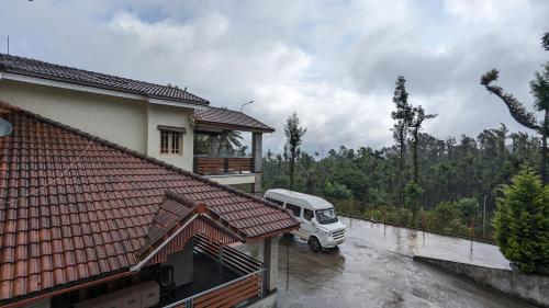 a van parked in a parking lot next to a house at Ridge Homestay in Mudigere