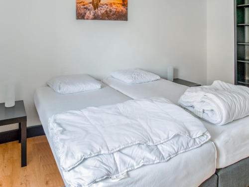 two beds in a room with white sheets at Holiday Home near Ravel Cycling paths in Heuem